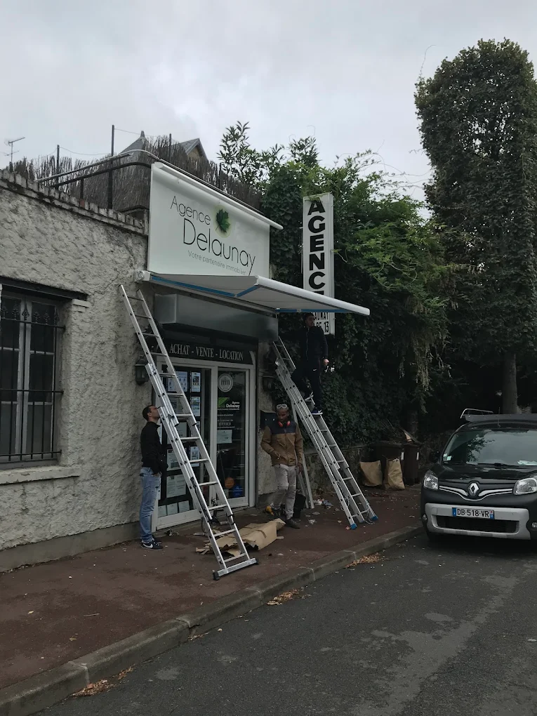 Store banne en cours d’installation sur une devanture commerciale