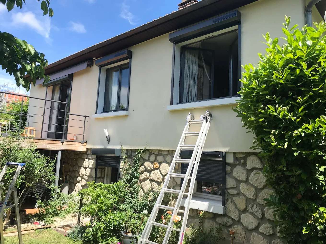 Installation de volets roulants sur une maison, échelle contre la façade